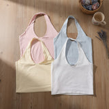 Four halter neck crop tops in pale pink, light blue, cream and white laid flat
