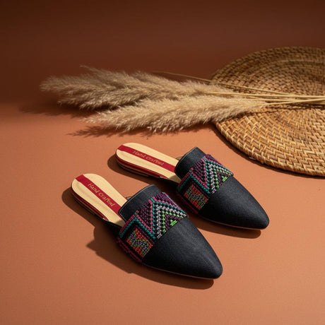 Pair of handmade jeans slippers with colorful patterns on a brown background