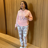 Women's pink hooded pyjama set with bunny print pants against a wooden wall - Jack Gifts Online Lebanon