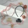 Pink and black slim headbands with two matching claw clips in cream and grey, styled with ribbon and dried flowers