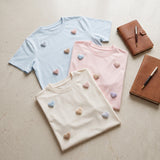 Three heart applique t-shirts in light blue, pink and cream laid flat