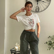 Heart print crop tee styled with khaki green trousers and a raised hand