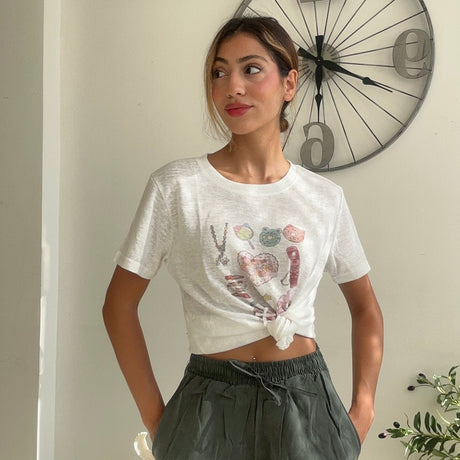 White crop tee with a heart print worn with khaki green wide leg trousers
