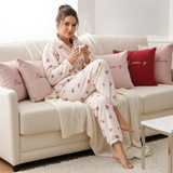 Woman relaxing on a sofa with a mug in heart print fleece pyjamas