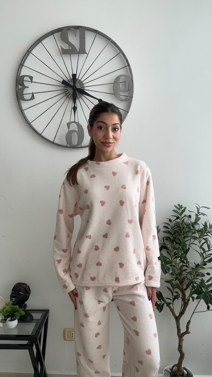 Cream fleece pyjama set with tiny pink hearts worn standing