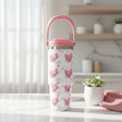 White travel mug with pink hearts and repeated love script and a pink carry handle