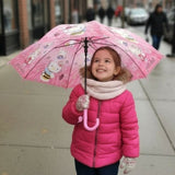 Girl on a street under an open pink Hello Kitty bee kids umbrella