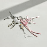 Hello Kitty keychain with pink ribbon and charms on a light surface