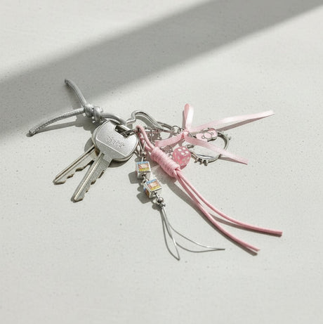 Hello Kitty keychain with pink ribbon and charms on a light surface