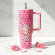 Pink Hello Kitty tumbler on white marble with scattered pink blooms