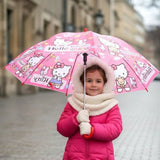 Girl in a pink coat holding an open coral pink Hello Kitty kids umbrella