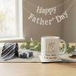 Mug and coaster set with 'I have a hero, I call him DAD' text on a glass surface.