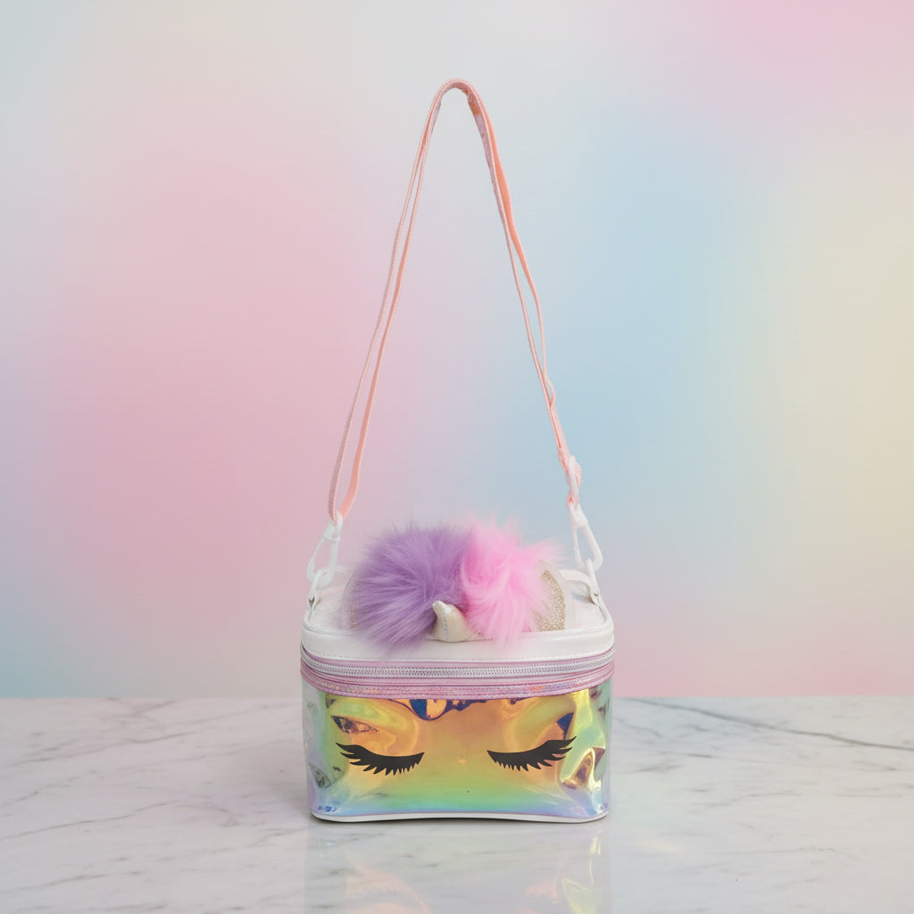 Boxy iridescent unicorn train case with lash print, a pink zip and a long cross body strap