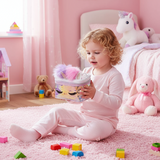 Toddler in a pink bedroom holding a shimmering unicorn vanity case with lilac and pink pom ears
