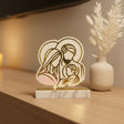 Gold line drawing of Mary, Joseph and the infant on acrylic beside dried pampas