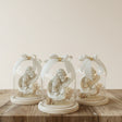Deeper carved Holy Family set straight on a turned wood disc among gypsophila
