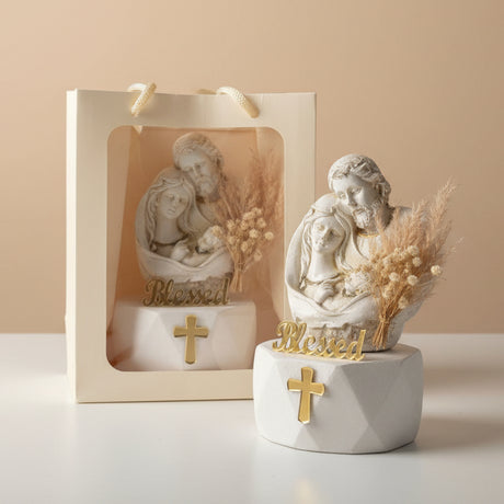 Ivory Holy Family relief beside a cream gift bag and a spray of dried pampas