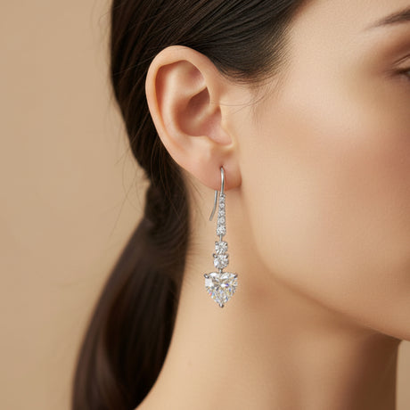 Close-up of a woman wearing elegant hook earrings with a neutral background