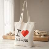 Cream canvas tote printed with a red heart above Batroun, hanging by a sunlit window