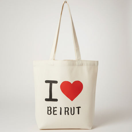 Cream canvas tote hanging by its long handles, printed with a red heart above Beirut