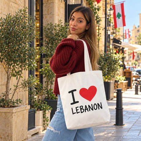 Woman carrying a cream canvas tote printed I love Lebanon with a red heart on a Lebanese street