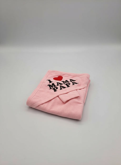 Pink hooded baby towel folded neatly with a red heart and bold black mama and papa lettering
