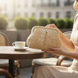Ivory crochet clutch bag held at outdoor cafe table, Jack Gifts Online Lebanon