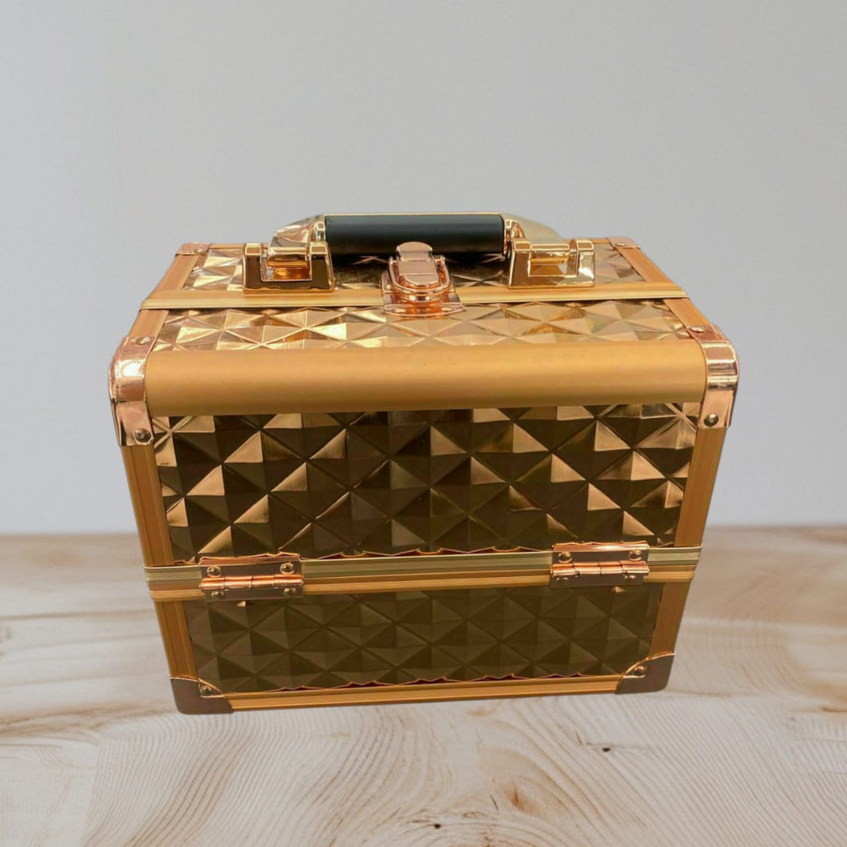 Gold studded aluminium case closed with rose gold corners and a black carry handle