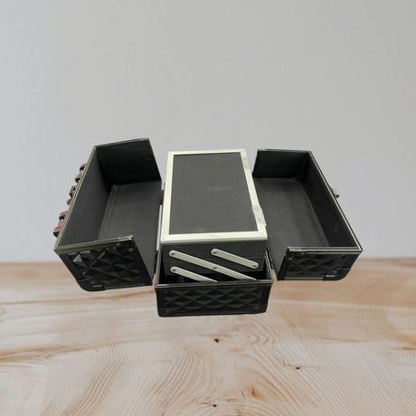 Interior of the vanity case with fold out side trays, a raised lid mirror and a deep base