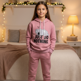 Dusty pink hoodie and joggers worn in a bedroom with warm fairy lights