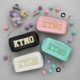 Four pouches with 'KTMO' branding on a grey surface with accessories