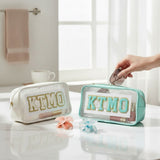 Two clear cosmetic bags with 'KTMO' branding on a bathroom counter