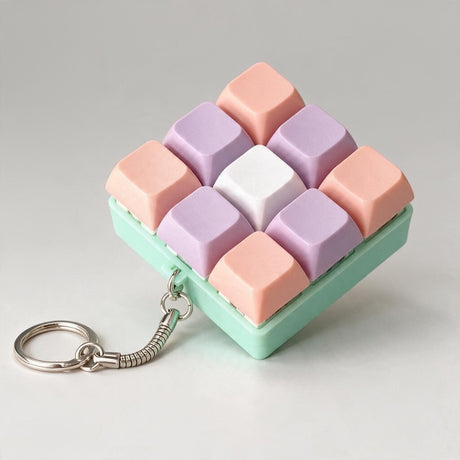 Coral and lilac keycap fidget with a white centre key on a mint base and a split ring