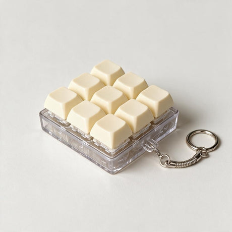 Cream keycap fidget clicker keychain with nine keys on a clear base