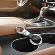 Kia car keychain on a car cup holder with a blurred interior background