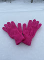 Hot pink knitted gloves laid side by side on snow