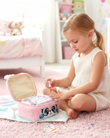 Girl painting her nails beside the open manicure case with sticker sheets on the rug