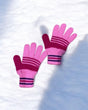 Two tone pink knitted gloves with magenta stripes on snow