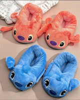 Pink and blue plush slippers with big cartoon eyes and floppy ears side by side