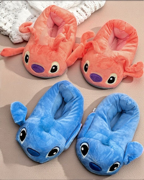 Pink and blue plush slippers with big cartoon eyes and floppy ears side by side