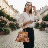 Woman carrying a terracotta kilim frame bag on a gold chain strap