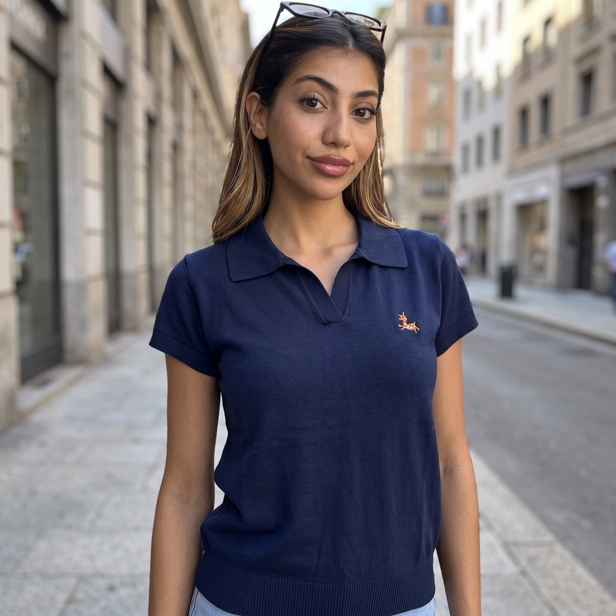 Navy knit polo top with a flat shirt collar and ribbed sleeve cuffs