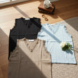 Three sleeveless knit tops with lace trim in black, light blue and beige laid flat