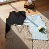Three sleeveless knit tops with lace trim in black, light blue and beige laid flat