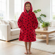 Girl in a red ladybird spot hooded blanket in a bright room