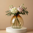 Large balloon round amber vase filled with hydrangea, peonies and eucalyptus