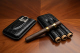 Cigar case with cigars and a cutter on a wooden surface