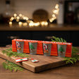 Four frosted glass tumblers printed with a green cedar over a gold hill and a red scroll