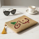 Jute zip pouch with the same Arabic calligraphy stitched in deep burgundy thread