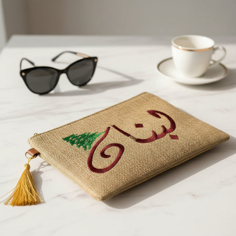 Jute zip pouch with the same Arabic calligraphy stitched in deep burgundy thread